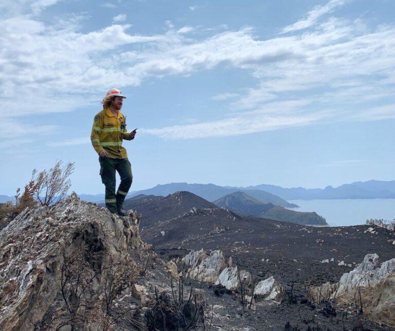 A firefighter looks over the view of the area after a fire. Photo Credit: Tasmania Parks and Wildlife Service 